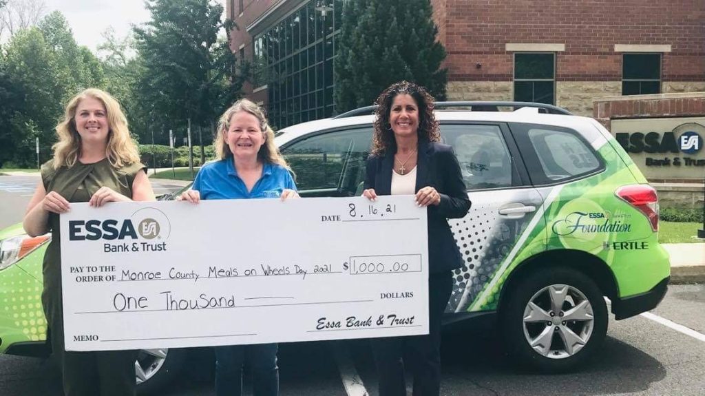 three women holding a check for Monroe County Meals on Wheels for 1,000 dollars