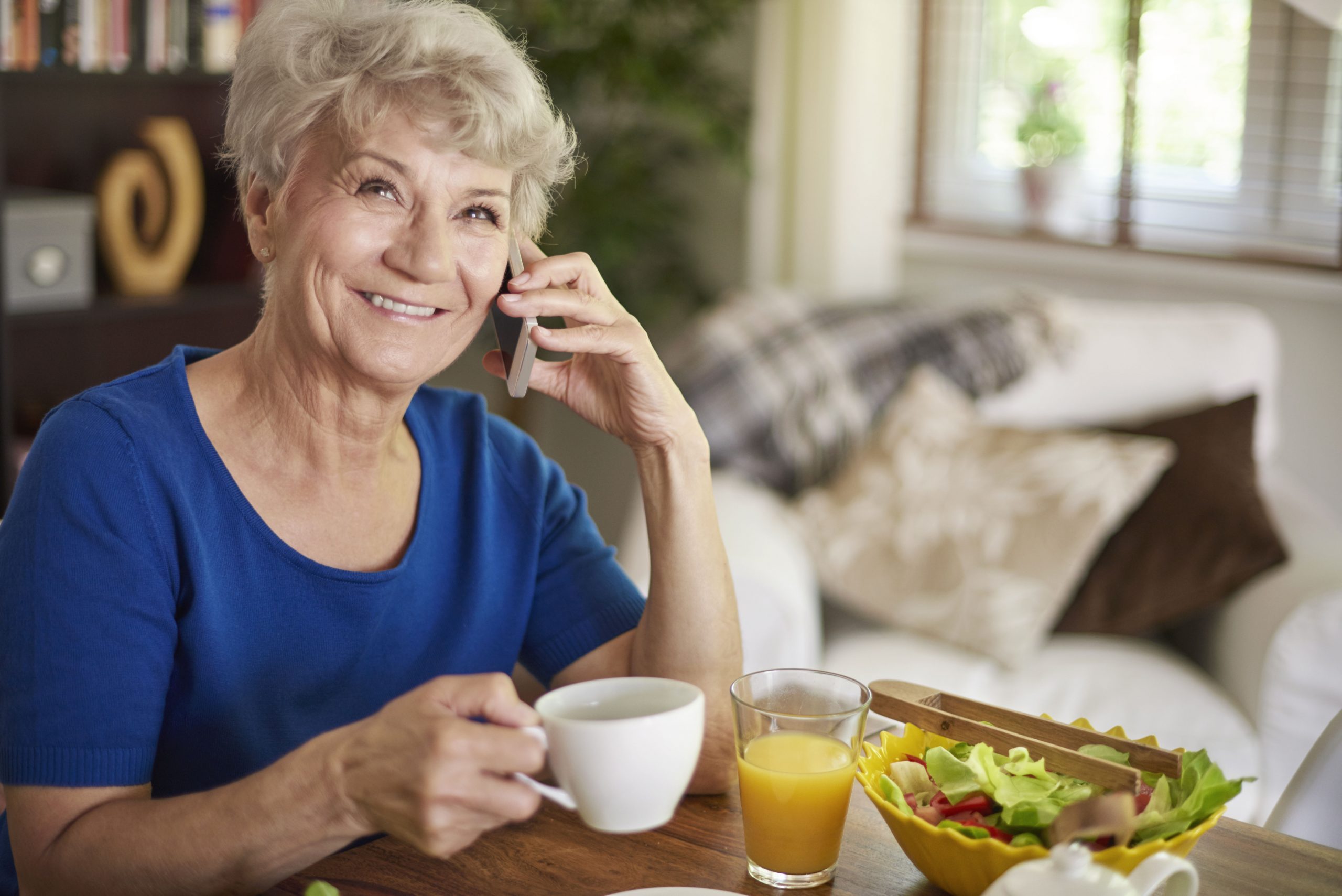 Woman calling in to the TeleBank feature about her bank account while eating lunch