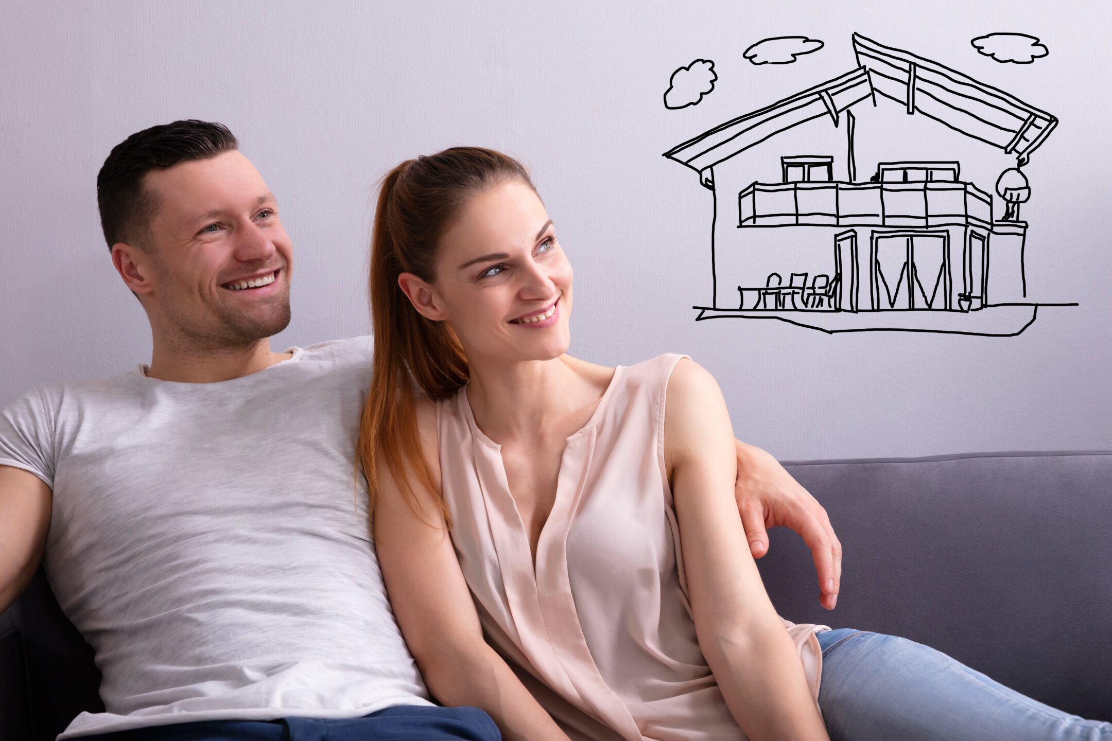 Man and woman on a couch thinking about their dream home