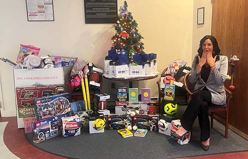 Maria Kelly near a mini christmas tree for Toys for Tots Drive 2022