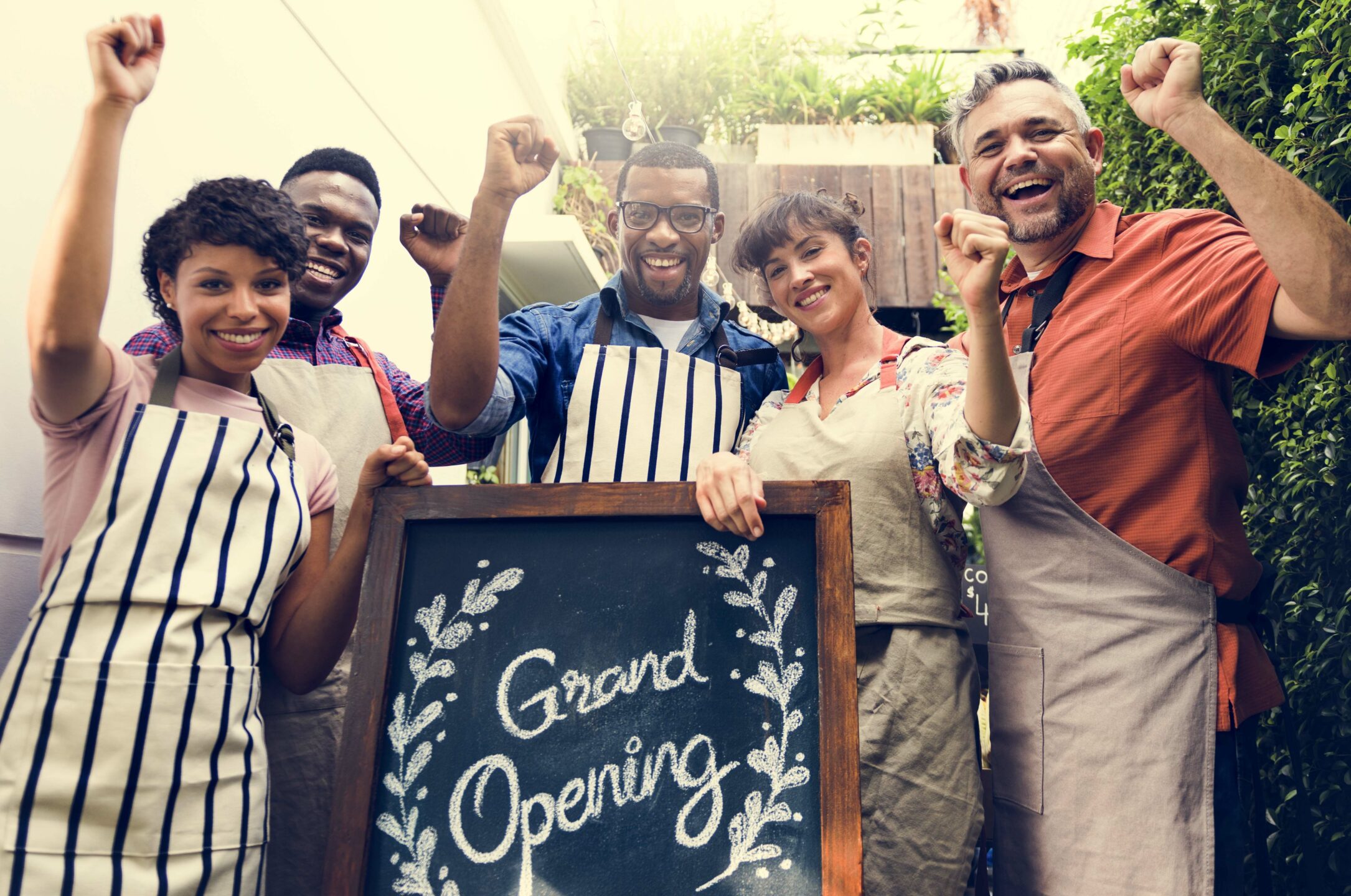 Group of friends with grand opening board together
