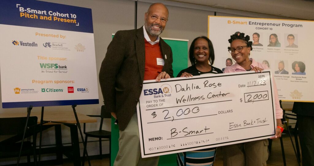 Woman receives check from Pitch Competition. 