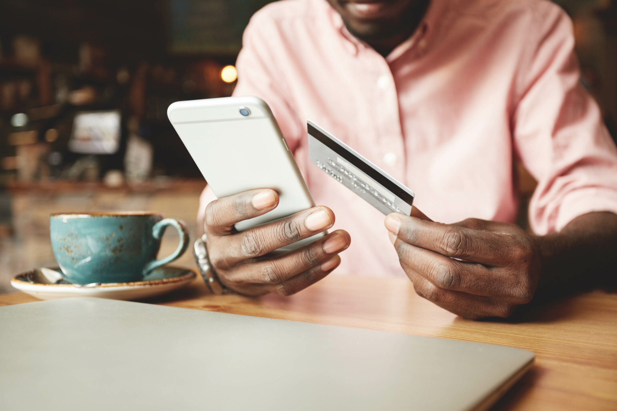 African,American,Man,In,Casual,Shirt,Paying,With,Credit,Card African American man in casual shirt paying with credit card online while making orders via the Internet. Successful black businessman making transaction using mobile bank application. Selective focus